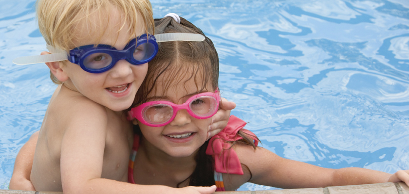 Girl and boy having fun in a swimmming pool
